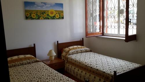 twee bedden in een kamer met een raam bij Casa vacanze Mare in Parghelia