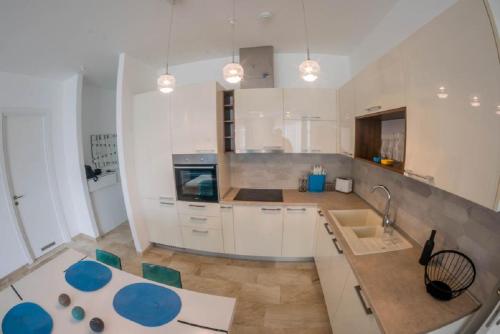 a kitchen with white cabinets and a counter top at Apartment Mimosa of Tre Canne in Budva