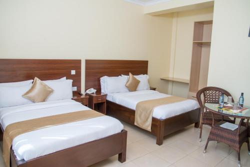 a hotel room with two beds and a table at Delfirm Hotel in Nairobi