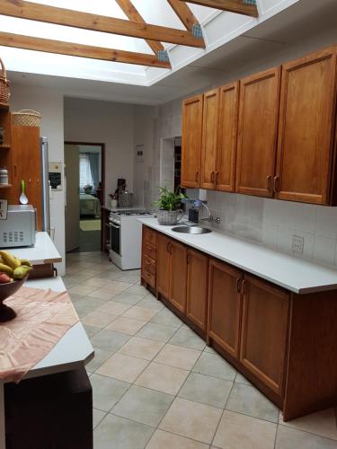 a large kitchen with wooden cabinets and white appliances at 57 Simon Van Der Stel Street in Port Edward