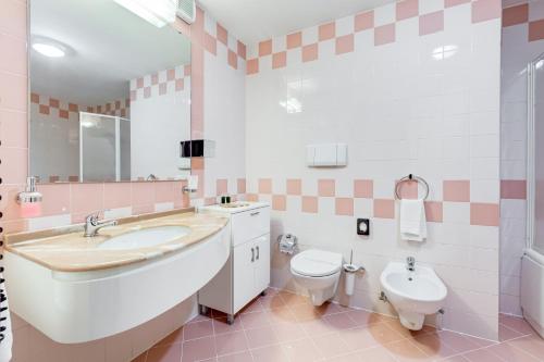 a pink and white bathroom with a sink and a toilet at Best Western Hotel Imperiale in Nova Siri Marina
