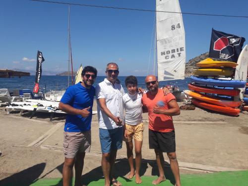 a group of four men posing for a picture on a boat at Paradise Gümüşlük in Gümüşlük