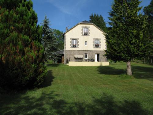 a large white house with a tree in the yard at La maison in Tarnac