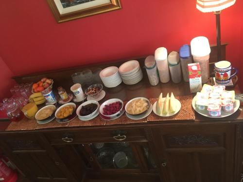 a table with plates and bowls of food on it at Carnside Guest House in Bushmills