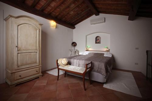 Agriturismo Le Pianore في مونتيزبيرتولي: غرفة نوم بسرير وخزانة خشبية