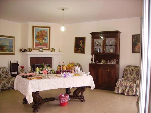 a living room with a table and a fireplace at Villa Linda Bed And Breakfast in Sulmona