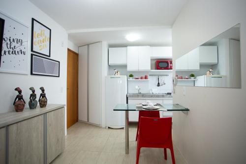 cocina con mesa y silla roja en FLAT BOA VIAGEM PRÓXIMO A PRAIA, en Recife