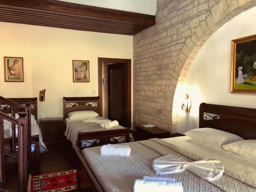 three beds in a room with a brick wall at White House Boutique Hotel & Restaurant - since 1999 in Berat