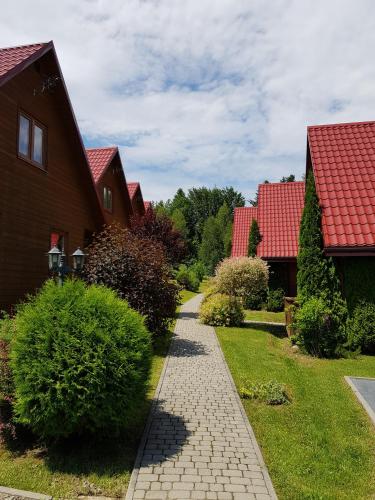 a walkway between two houses with red roofs at Domki Nad Krystaliczną Zatoką in Polańczyk
