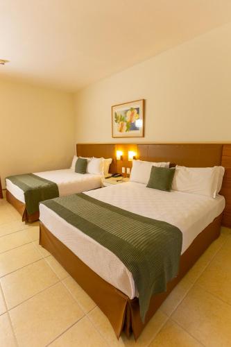 a hotel room with two beds in a room at Hotel JP Ribeirão Preto Resort & Convenções by Nacional Inn in Ribeirão Preto