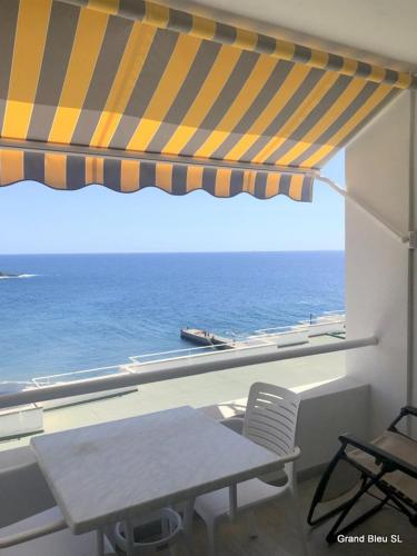 a table and chairs in front of a window with the ocean at El Ancla - El Mar y La Playa in Callao Salvaje