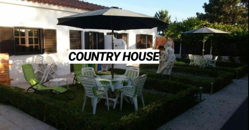 un patio con mesa, sillas y sombrilla en Country House Alfarim, en Alfarim