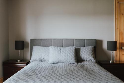 a bedroom with a bed with two nightstands and two lamps at The Kitch'inn - Boutique Inn and Wine Bar in Mahone Bay