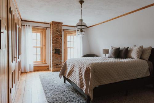 a bedroom with a bed and a brick wall at The Kitch'inn - Boutique Inn and Wine Bar in Mahone Bay