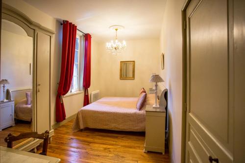 コンドンにあるLes Hauts de Condom Appartements Climatisesの小さなベッドルーム(ベッド1台、赤いカーテン付)