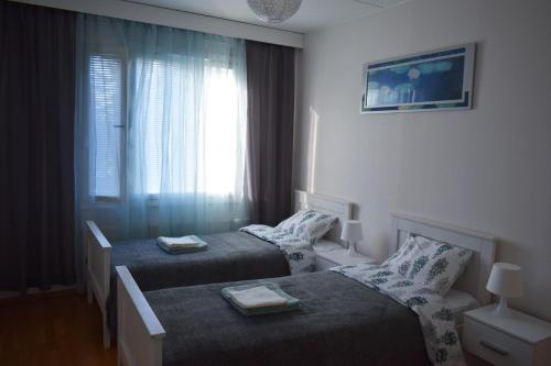 a hotel room with two beds and a window at RANTA in Tampere