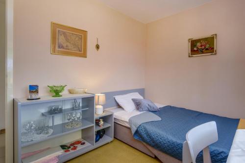 a bedroom with a bed and a shelf with glasses at SheShe in Mali Lošinj