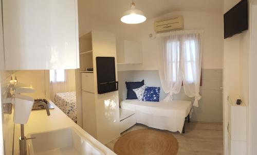 a small white room with a bed and a sink at Villaggio Baia Dei Lombardi in Vieste