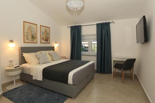 Un dormitorio con una cama y una silla y un televisor. en Apartments Bonvenon2Pula, en Pula