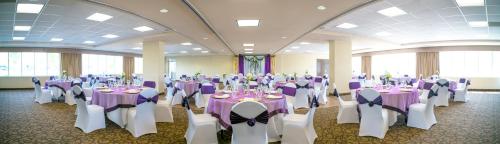 a banquet hall with purple and white tables and chairs at Acclaim Hotel by CLIQUE in Calgary