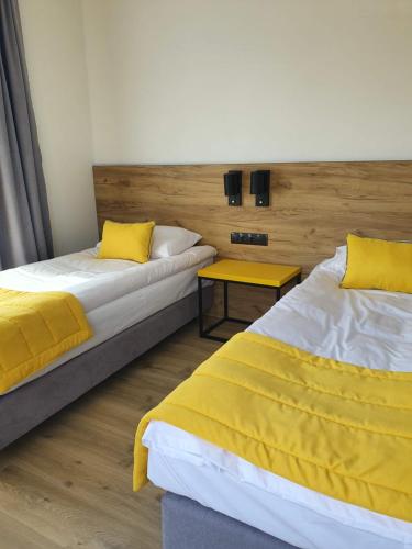 two beds with yellow pillows in a room at VILLA 17 Noclegi in Płock