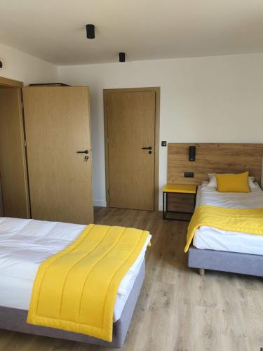 two beds with yellow sheets in a room at VILLA 17 Noclegi in Płock