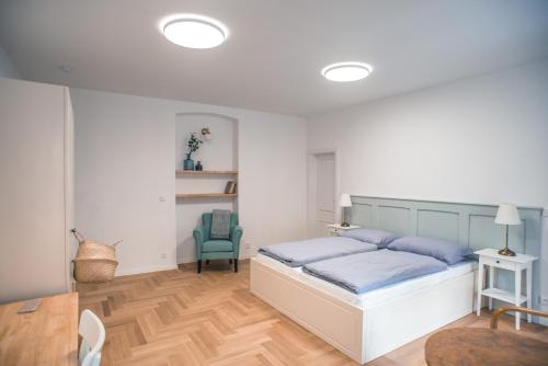a bedroom with a bed and a blue chair at Penzion Masarykova 37 Hluboká nad Vltavou in Hluboká nad Vltavou