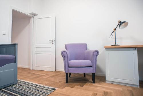 a purple chair in a room with a lamp at Penzion Masarykova 37 Hluboká nad Vltavou in Hluboká nad Vltavou