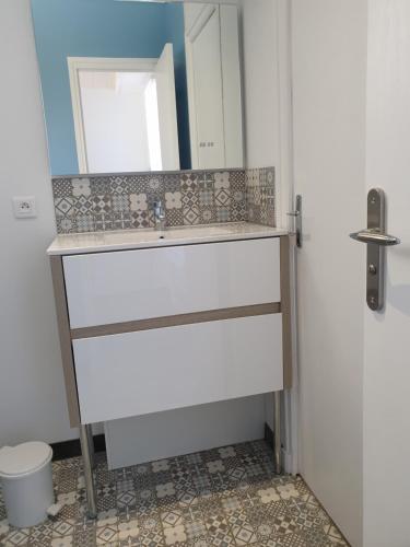 La salle de bains est pourvue d'un lavabo, d'un miroir et de toilettes. dans l'établissement Pousse le portail et pose toi sur la plage, à Noirmoutier-en-l'lle