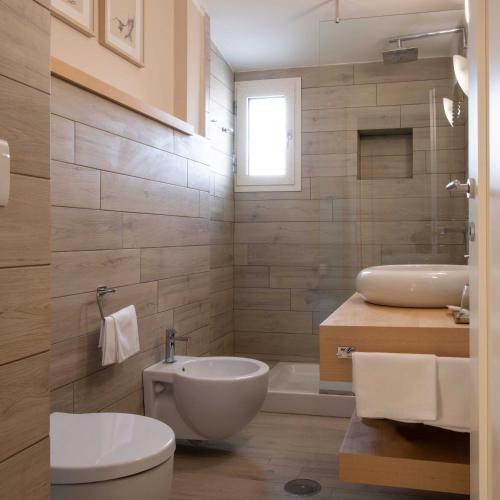 a bathroom with a toilet and a sink and a tub at Welchome Charming House in Caserta