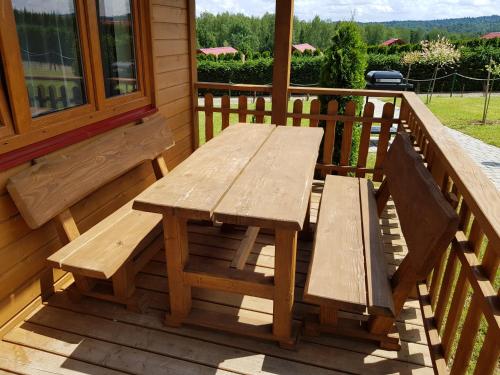 a wooden picnic table on the porch of a house at Domki Nad Krystaliczną Zatoką in Polańczyk