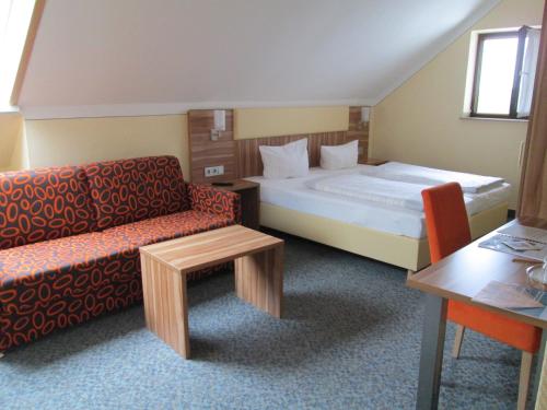 a hotel room with a bed and a chair and a table at Landhotel Karrenberg in Kirchberg