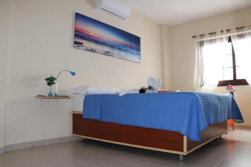 a bedroom with a blue bed in a room at Casa Yoel in Granadilla de Abona