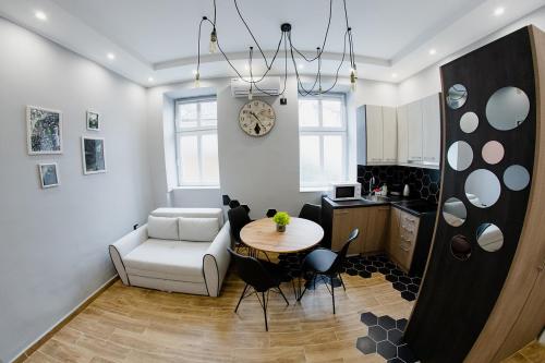 un soggiorno con tavolo e sedia e una cucina di Apartmani Galea a Sombor