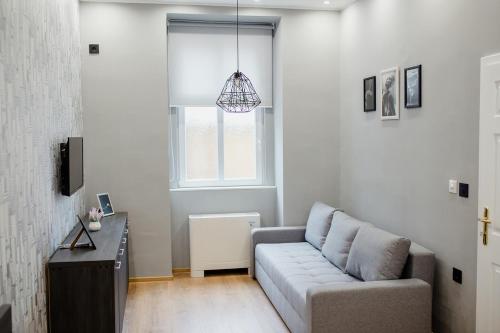 a living room with a couch and a window at Apartmani Galea in Sombor
