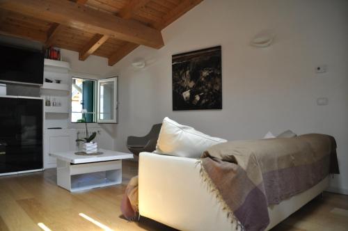 een woonkamer met een bank en een tv bij Casa Calle Pescheria in Grado