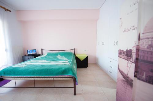 a bedroom with a bed with a green comforter at Elias Appartment in Volos