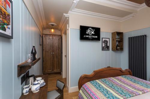 a bedroom with a bed and a table with a phone at McGettigan's Townhouse - Olives & Figs Bistro in Dublin