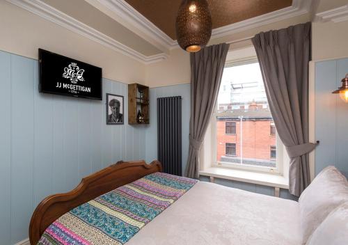 a bedroom with a bed and a window at McGettigan's Townhouse - Olives & Figs Bistro in Dublin