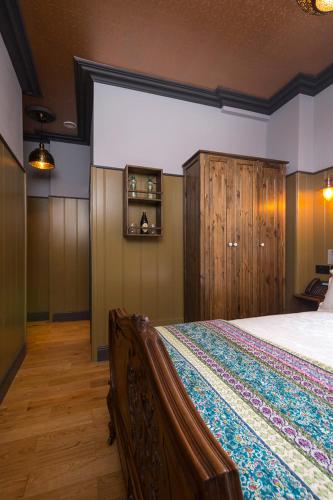 a bedroom with a large bed and wooden cabinets at McGettigan's Townhouse - Olives & Figs Bistro in Dublin