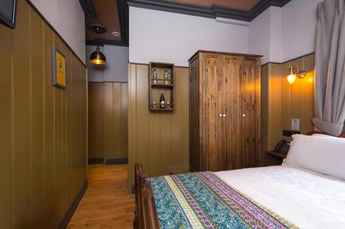 a bedroom with a bed and a wooden cabinet at McGettigan's Townhouse - Olives & Figs Bistro in Dublin