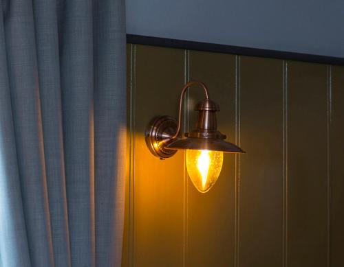a light hanging from a wall next to a curtain at McGettigan's Townhouse - Olives & Figs Bistro in Dublin