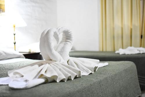 Una toalla encima de una cama en una habitación de hotel en Posada Pecos en Pinamar