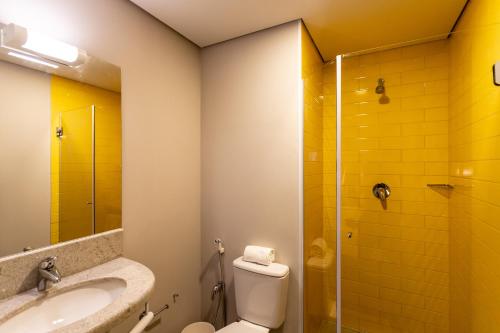 a bathroom with a toilet and a sink and a shower at ibis Palmas Avenida JK in Palmas