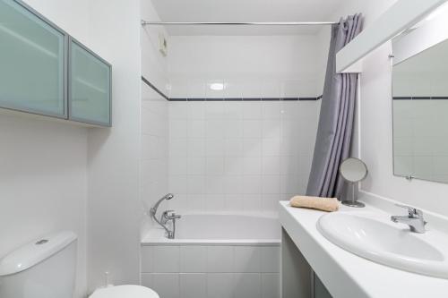 uma casa de banho branca com um lavatório, uma banheira e um WC. em A 5 min de Bordeaux centre - Terrasse - Pied du tram em Cenon