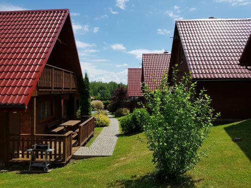 a house with a porch and a walkway between two buildings at Domki Nad Krystaliczną Zatoką in Polańczyk