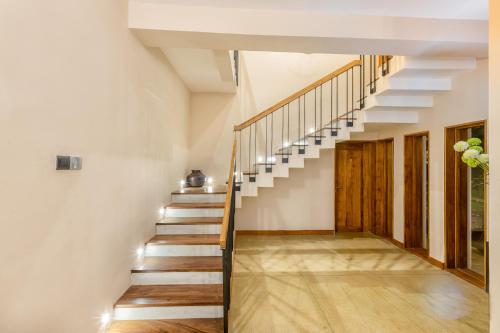 a staircase in a house with white walls and wooden floors at Aryana Boutique Hotel in Anuradhapura