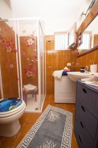a bathroom with a shower and a toilet and a sink at Poggio degli Oleandri in Nettuno