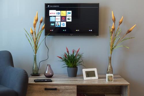 a living room with a tv and a table with plants at HaPPy Inn Presidential, Self check-in, Parking in the underground garage in Vilnius