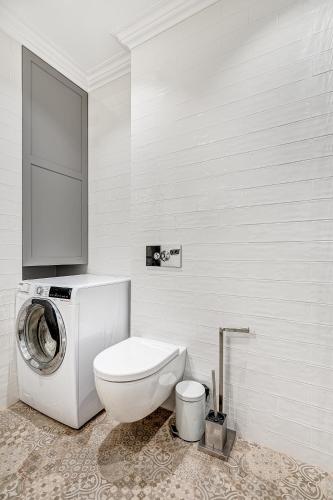 a bathroom with a toilet and a washing machine at HaPPy Inn Presidential, Self check-in, Parking in the underground garage in Vilnius